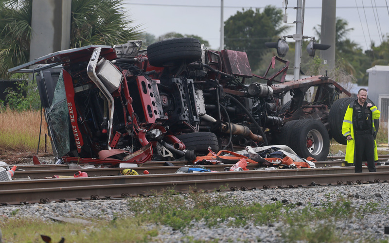 15 hurt when passenger train strikes fire truck that drove into crossing after freight train passed